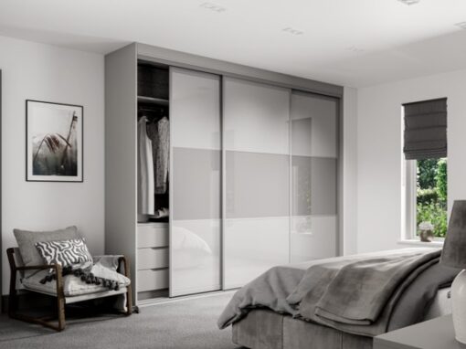 Sliding wardrobe from the FORM range with split grey and white glass panels in a bedroom