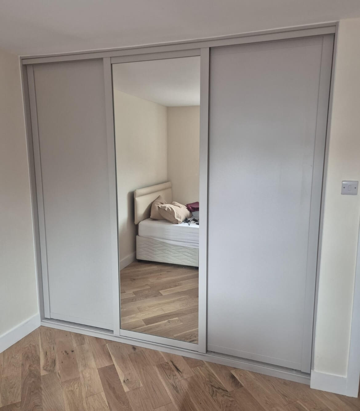 Fitted sliding wardrobe in Aldridge with an oyster-grey frame and a full-panel mirror door
