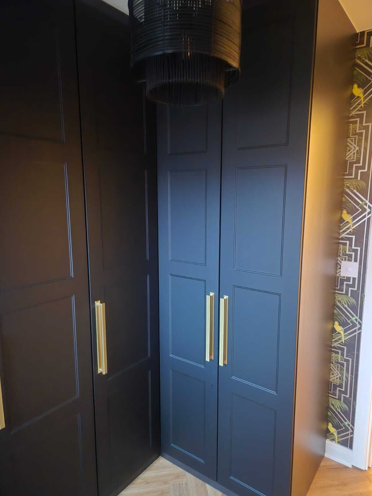 Navy hinged shaker wardrobe fitted into a corner in Aldridge with brass bar handles and shaker-panel doors