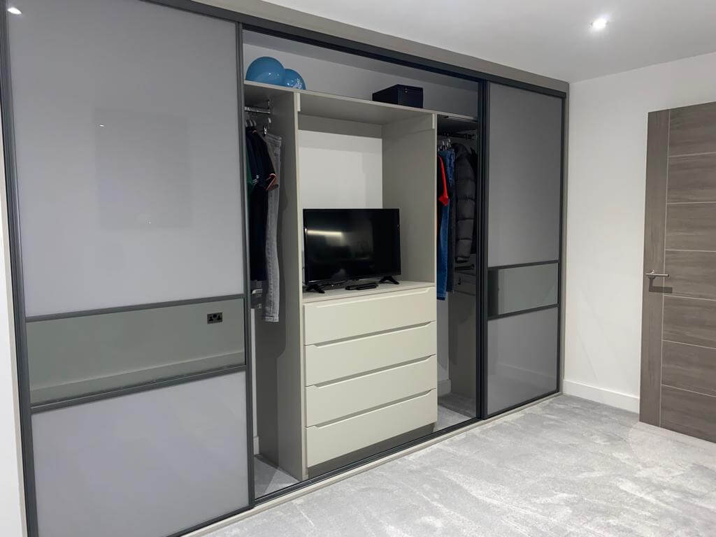 Close-up of a navy shaker wardrobe in Aldridge showing the panelled doors and brass bar handles