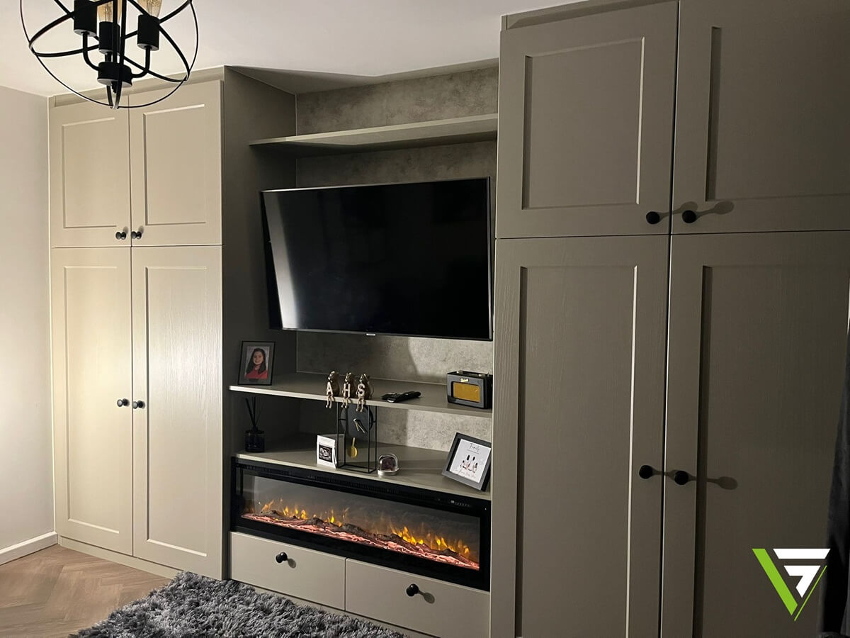 Shaker-style fitted wardrobe media wall in Aldridge with a Cashmere finish, built-in electric fireplace, TV recess and drawer storage