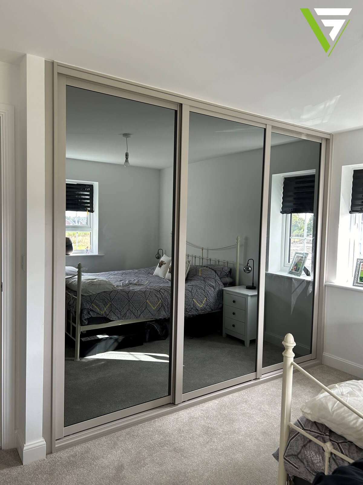 A recent Cannock new-build fit - three grey-tinted mirror sliding doors in a soft Cashmere shaker frame, made to measure floor to ceiling.