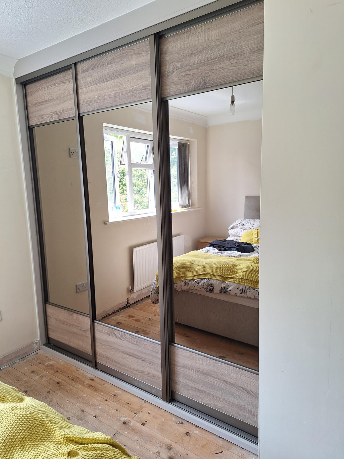 VERTEX sliding wardrobe in Stafford with bronze mirror doors, grey Bardolino oak panels and a champagne frame