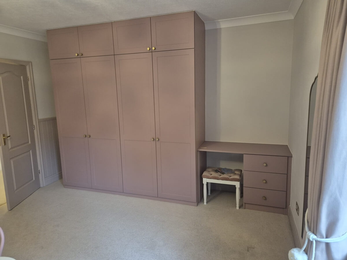 Dusky pink shaker fitted wardrobe with a built-in dressing table and drawers, fitted in a Sutton Coldfield bedroom by Vesta Space