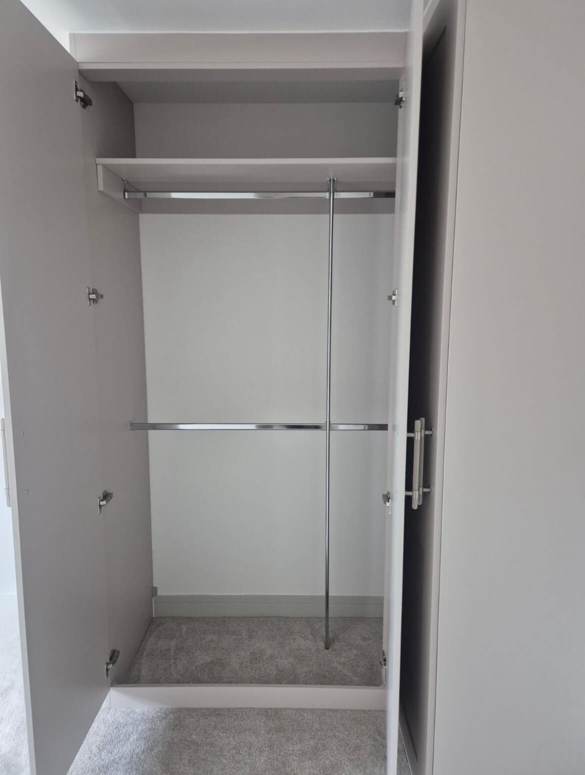 Fitted wardrobe interior with a top shelf and double hanging rails, in a Boldmere, Sutton Coldfield new-build