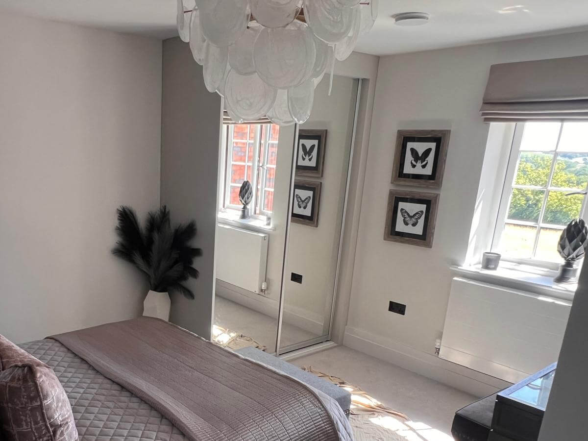 Bedroom in Tamworth with two silver mirror sliding wardrobe doors reflecting the window