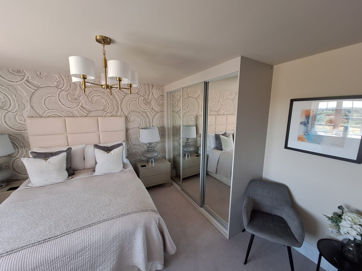 Three full-height silver mirror sliding wardrobe doors on a FORM frame beside a double bed in a Tamworth bedroom
