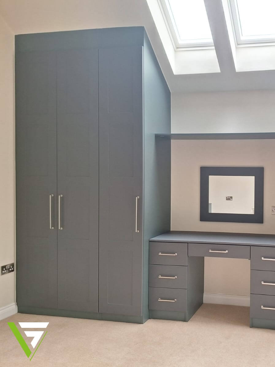 Heritage Green fitted wardrobe with a dressing table and drawer units built alongside in a Tamworth bedroom