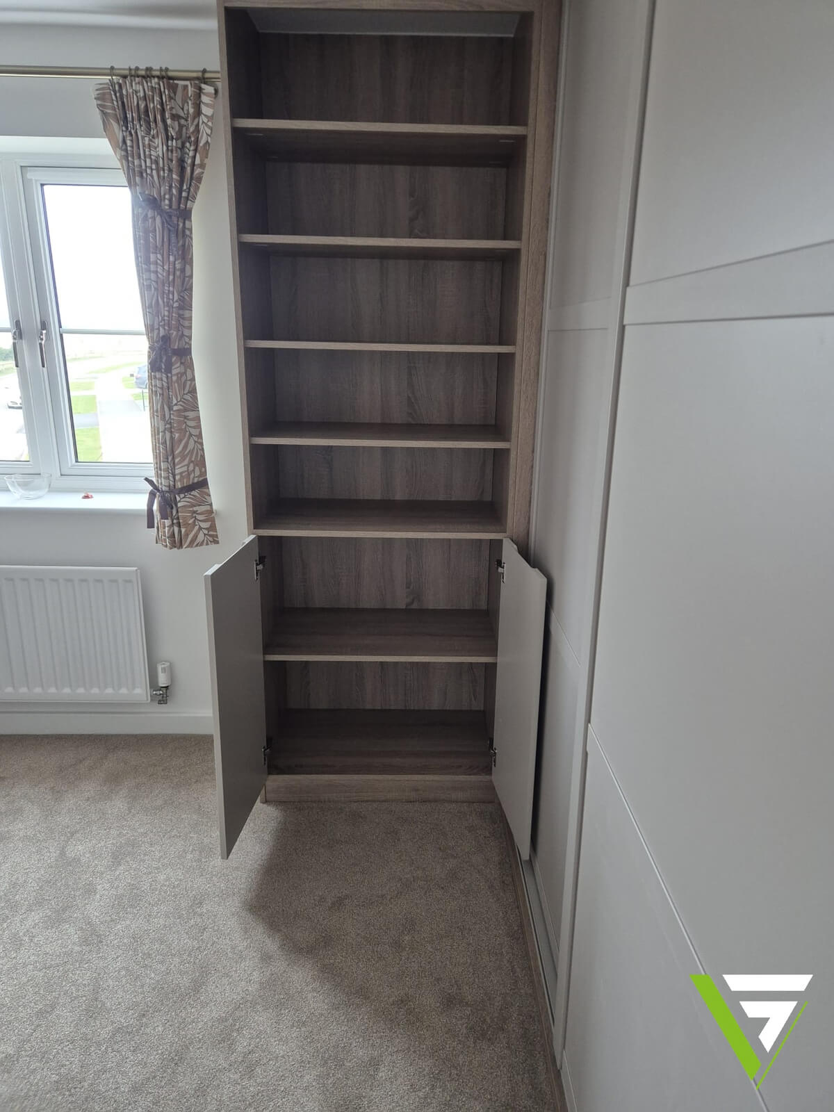 Oak-effect bookcase with a cupboard below, built beside Cashmere SHAKER sliding wardrobe doors in Tamworth