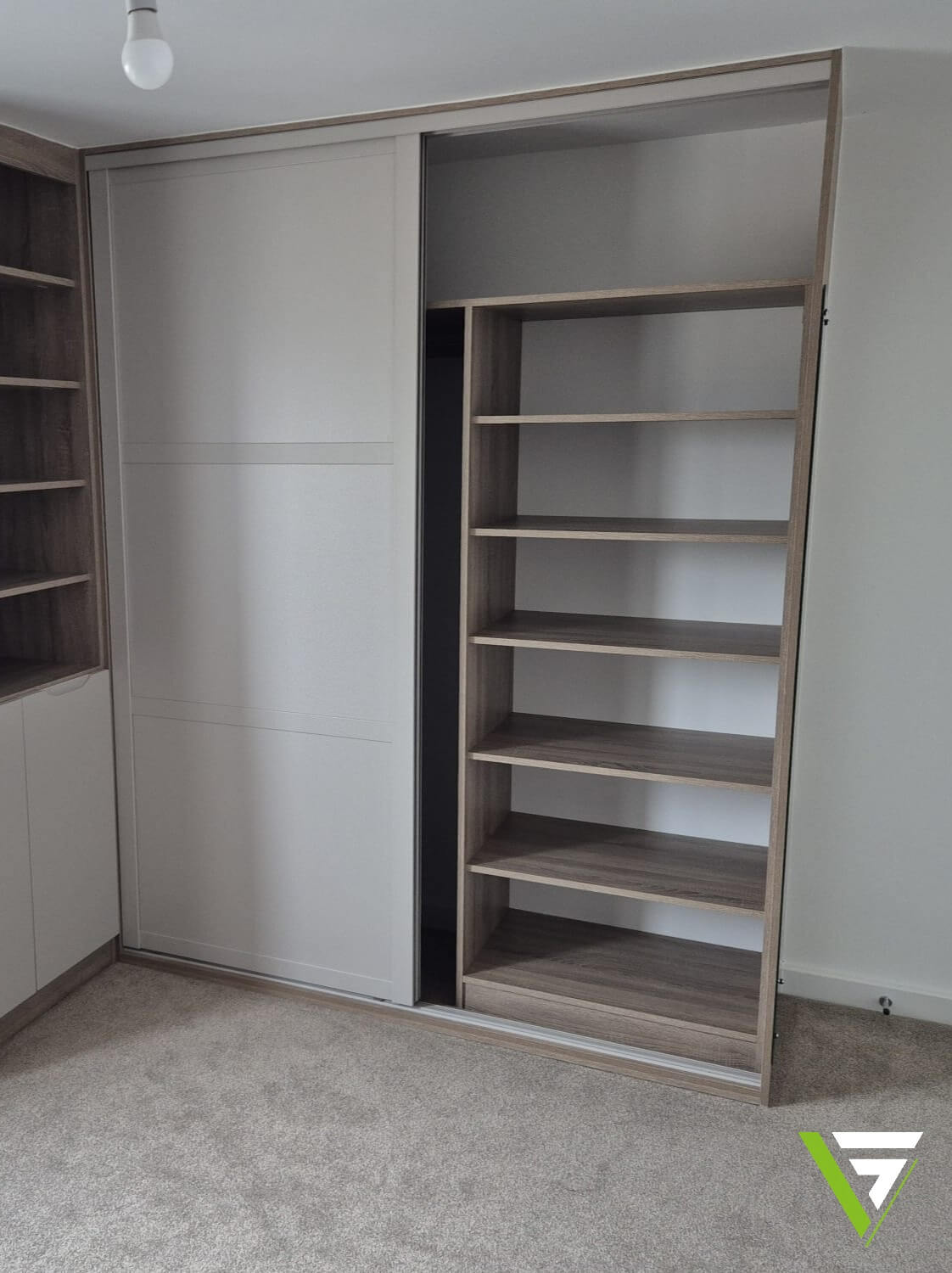 The same Tamworth wardrobe with one sliding door open, showing a custom shelf stack inside