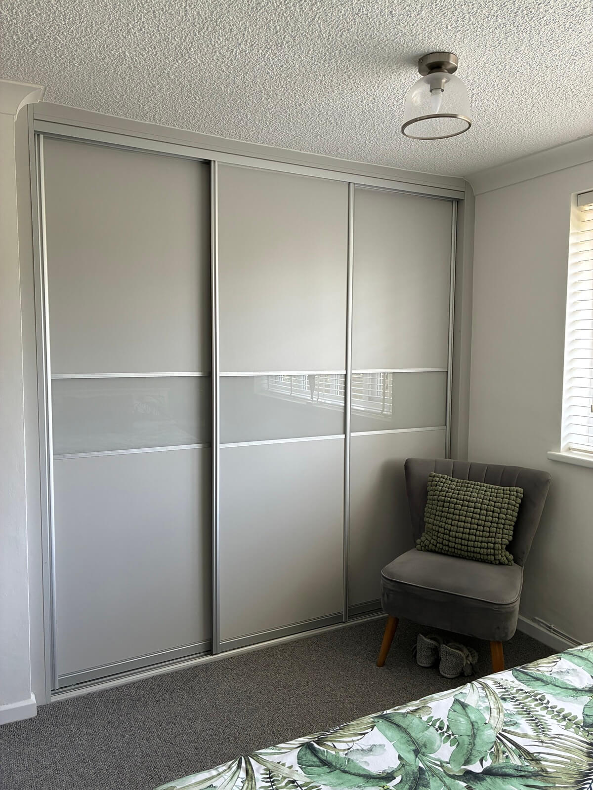 Light grey FORM sliding wardrobe with a silver frame and frosted glass band, fitted in a Walsall bedroom