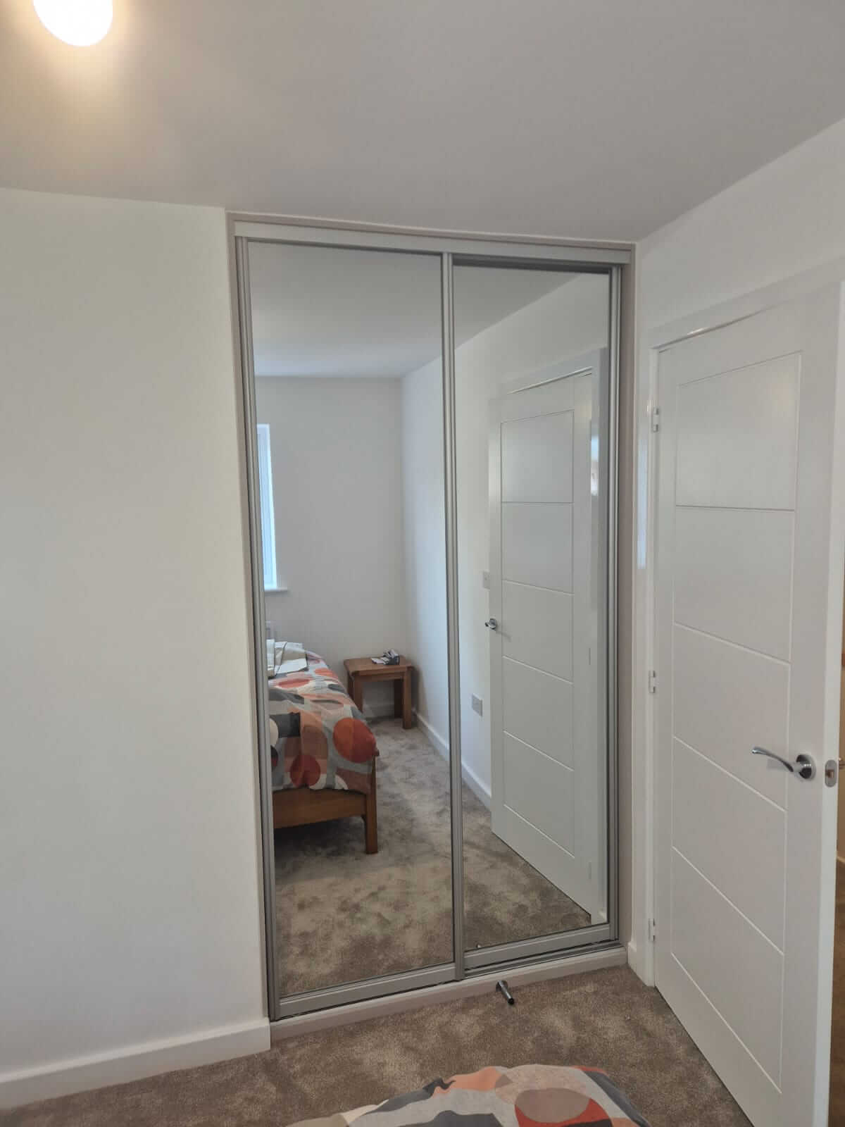 Silver FORM sliding wardrobe with full-panel silver mirror doors in a Walsall bedroom