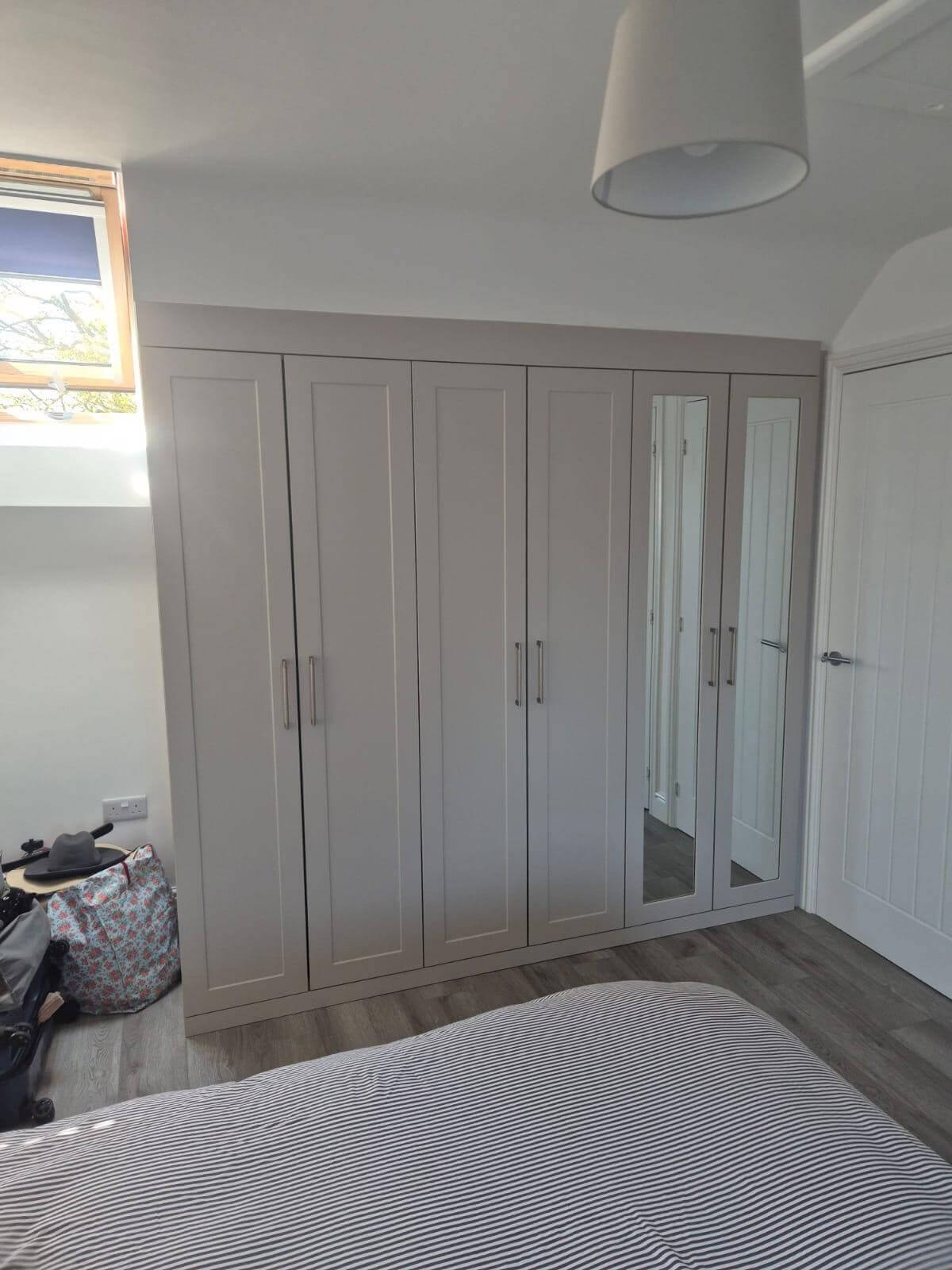 Shaker-style hinged wardrobes with a full-length mirror door, silver bar handles, Derby bedroom