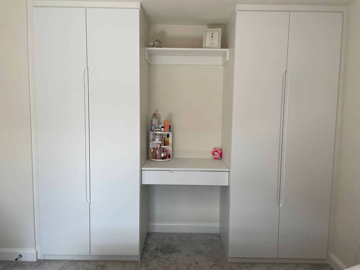 White hinged wardrobes either side of a built-in dressing table nook with shelf, Fradley, Lichfield