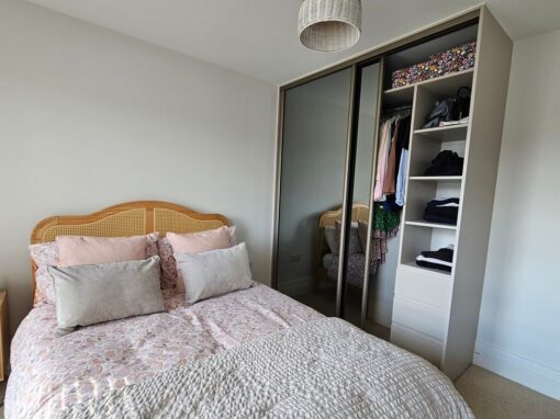 Two-door grey glass sliding wardrobe with a Cashmere frame beside an open shelf tower and drawers