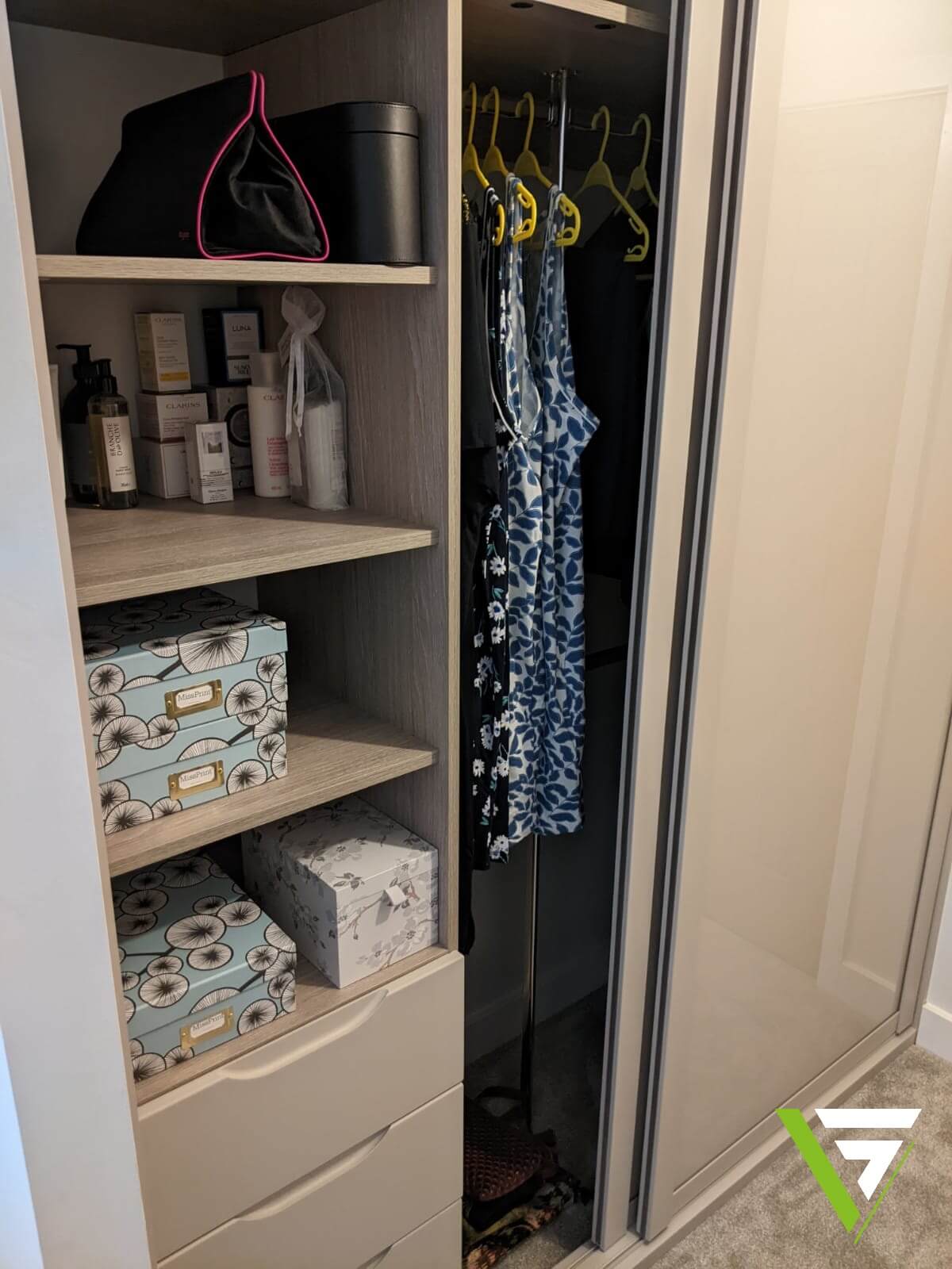 Wardrobe interior with cashmere shelves, a hanging rail and drawers, storing dresses, boxes and accessories